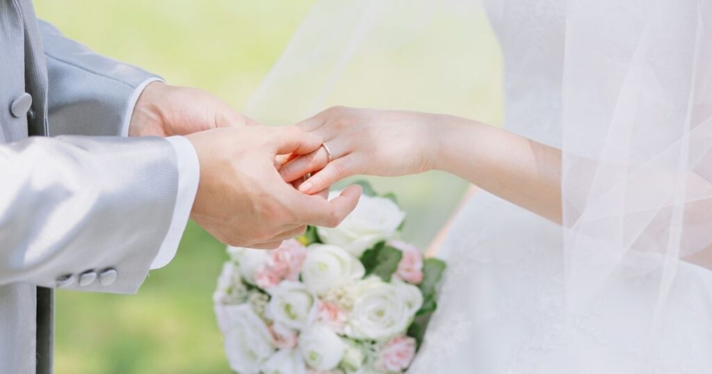 結婚　男性が女性に指輪をはめている